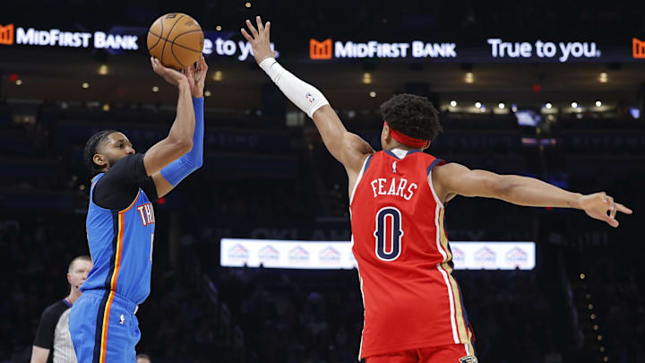Jan 27, 2026; Oklahoma City, Oklahoma, USA; Oklahoma City Thunder guard Isaiah Joe (11) shoots a three point basket as New Orleans Pelicans guard Jeremiah Fears (0) defends during the second half at Paycom Center. Mandatory Credit: Alonzo Adams-Imagn Images