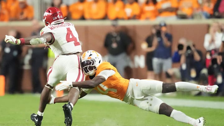 Tennessee defensive back Ty Redmond (4) brings down Arkansas running back Mike Washington Jr. (4) in an NCAA college football game on Oct. 11, 2025, in Knoxville, Tennessee.