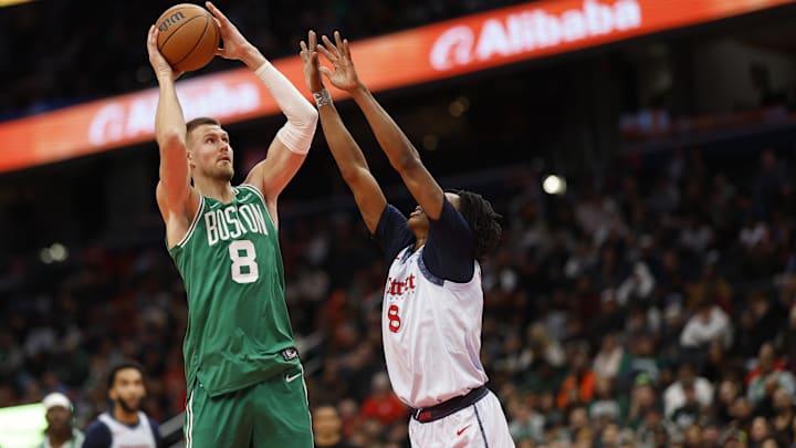 Dec 15, 2024; Washington, District of Columbia, USA; Boston Celtics center Kristaps Porzingis (8) shoots the ball as Washington Wizards guard Bub Carrington (8) defends in the second quarter at Capital One Arena. Mandatory Credit: Geoff Burke-Imagn Images