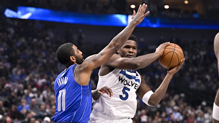 Minnesota Timberwolves guard Anthony Edwards looks to pass the ball past Dallas Mavericks guard Kyrie Irving during the first quarter at the American Airlines Center in Dallas on Dec. 25, 2024.