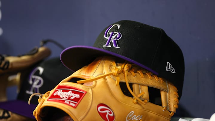 Jun 15, 2023; Atlanta, Georgia, USA; A detailed view of a Colorado Rockies hat and glove on the bench against the Atlanta Braves in the ninth inning at Truist Park. 