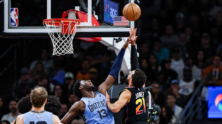 Dec 31, 2024; Phoenix, Arizona, USA; Phoenix Suns guard Tyus Jones (21) makes a lay up while Memphis Grizzlies forward-center Jaren Jackson Jr. (13) attempts to block him during the second quarter at Footprint Center. Mandatory Credit: Aryanna Frank-Imagn Images