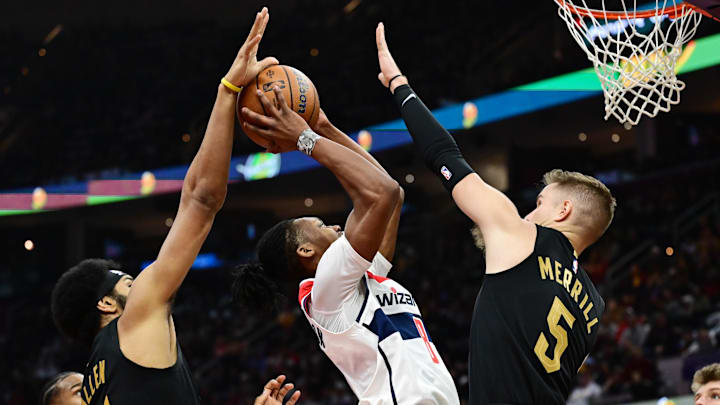 Dec 3, 2024; Cleveland, Ohio, USA; Washington Wizards guard Carlton Carrington (8) drives to the basket between Cleveland Cavaliers center Jarrett Allen (31) and guard Sam Merrill (5) during the first half at Rocket Mortgage FieldHouse. Mandatory Credit: Ken Blaze-Imagn Images