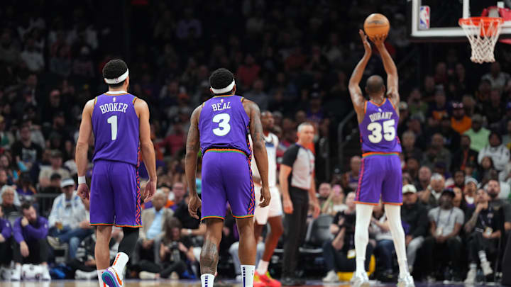 Mar 2, 2025; Phoenix, Arizona, USA; Phoenix Suns guard Devin Booker (1) and Phoenix Suns guard Bradley Beal (3) watch as Phoenix Suns forward Kevin Durant (35) shoots a free throw against the Minnesota Timberwolves during the first half at Footprint Center. Mandatory Credit: Joe Camporeale-Imagn Images