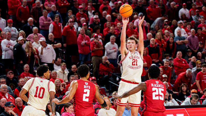 Dec 10, 2025; Lincoln, Nebraska, USA; Nebraska Cornhuskers forward Pryce Sandfort (21) shoots a three point basket against Wisconsin Badgers guard Nick Boyd (2) and guard John Blackwell (25) during the first half at Pinnacle Bank Arena. Dec 10, 2025; Lincoln, Nebraska, USA; Nebraska Cornhuskers forward Pryce Sandfort (21) shoots a three point basket against Wisconsin Badgers guard Nick Boyd (2) and guard John Blackwell (25) during the first half at Pinnacle Bank Arena.