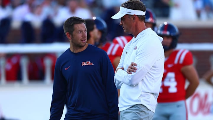 Aug 30, 2025; Oxford, Mississippi, USA; Mississippi Rebels head coach Lane Kiffin (right) talks with offensive coordinator Charlie Weis Jr. during warm ups prior to the game against the Georgia State Panthers at Vaught-Hemingway Stadium. Mandatory Credit: Petre Thomas-Imagn Images