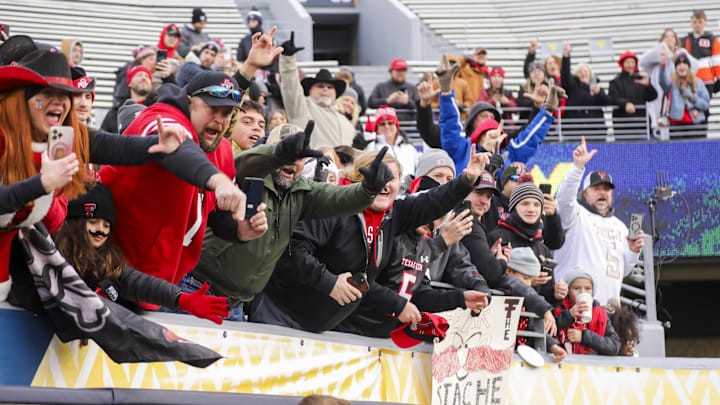 Nov 29, 2025; Morgantown, West Virginia, USA; Texas Tech Red Raiders fans cheer as Texas Tech Red Raiders head coach Joey McGuire greets them after defeating the West Virginia Mountaineers at Milan Puskar Stadium. Mandatory Credit: Ben Queen-Imagn Images