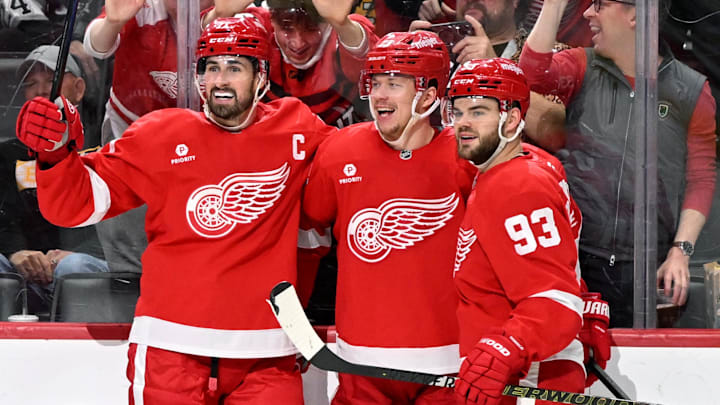Mar 29, 2025; Detroit, Michigan, USA; Detroit Red Wings left wing Lucas Raymond (23) celebrates with Detroit Red Wings center Dylan Larkin (71) and Detroit Red Wings right wing Alex DeBrincat (93) after scoring a power play goal against the Boston Bruins in the second period at Little Caesars Arena. Mandatory Credit: Lon Horwedel-Imagn Images