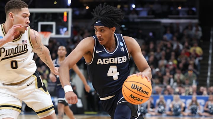 Mar 24, 2024; Indianapolis, IN, USA; Utah State Aggies guard Ian Martinez (4) dribbles against Purdue Boilermakers forward Mason Gillis (0) during the first half at Gainbridge FieldHouse. Mandatory Credit: Trevor Ruszkowski-Imagn Images
