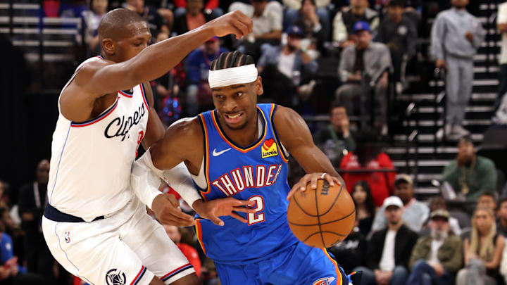 Mar 23, 2025; Inglewood, California, USA; Oklahoma City Thunder guard Shai Gilgeous-Alexander (2) drives against LA Clippers guard Kris Dunn (8) during the 3rd quarter at Intuit Dome. Mandatory Credit: Jason Parkhurst-Imagn Images