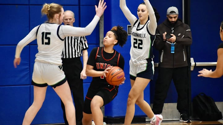 Woodinville's Kamryn Wille, left, and Jazzy Wilkerson surround Union's Myla Larry in Class 4A regional game at Bellevue College.