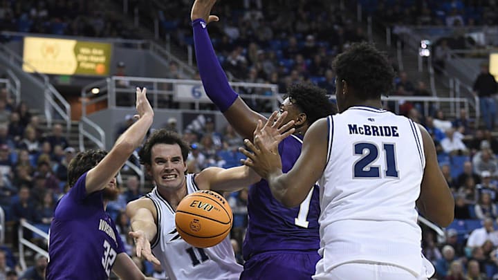 Nevada’s Nick Davidson passes between Great Osobor and Wilhelm Breidenbach of the Huskies.