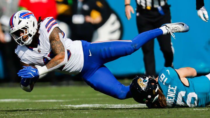 Jacksonville Jaguars quarterback Trevor Lawrence (16) tackles Buffalo Bills linebacker Shaq Thompson (45) after throwing an interception during the first quarter in an NFL football AFC Wild Card playoff matchup.