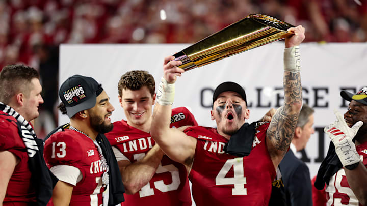 Indiana linebacker Aiden Fisher holds up the College Football Playoff national championship trophy.