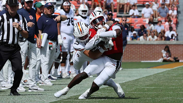 Sep 13, 2025; Auburn, Alabama, USA;  South Alabama Jaguars running back Keenan Phillips (21) is tackled by Auburn Tigers safety Eric Winters (25) during the fourth quarter at Jordan-Hare Stadium. Mandatory Credit: John Reed-Imagn Images