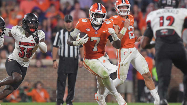 Nov 2, 2024; Clemson, South Carolina, USA; Clemson Tigers running back Phil Mafah (7) runs the ball against Louisville Cardinals linebacker Antonio Watts (35) during the second quarter at Memorial Stadium. 