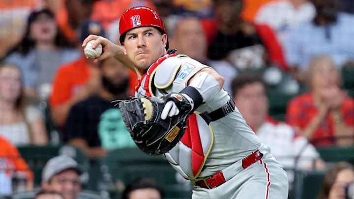 Jun 24, 2025; Houston, Texas, USA; Philadelphia Phillies catcher J.T. Realmuto (10) throws a passed ball to first base for an out against the Houston Astros during the third inning at Daikin Park. Mandatory Credit: Erik Williams-Imagn Images