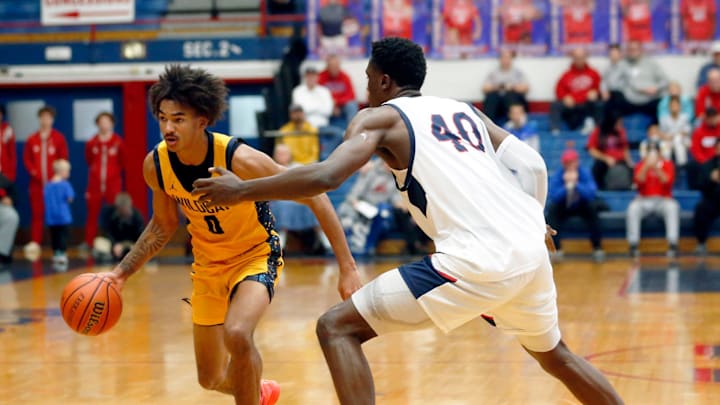 South Bend Riley senior Payton Baird (0) dribbles the ball while being defended by Kokomo senior Flory Bidunga (40)
