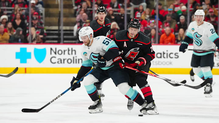Dec 3, 2024; Raleigh, North Carolina, USA; Carolina Hurricanes center Sebastian Aho (20) checks Seattle Kraken center Shane Wright (51) off the puck during the second period at Lenovo Center. Mandatory Credit: James Guillory-Imagn Images Dec 3, 2024; Raleigh, North Carolina, USA; Carolina Hurricanes center Sebastian Aho (20) checks Seattle Kraken center Shane Wright (51) off the puck during the second period at Lenovo Center. Mandatory Credit: James Guillory-Imagn Images
