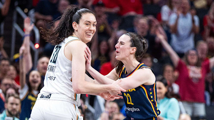 Indiana Fever guard Caitlin Clark (22) celebrates a made basket with New York Liberty forward Breanna Stewart (30)in the first half against the New York Liberty at Gainbridge Fieldhouse.