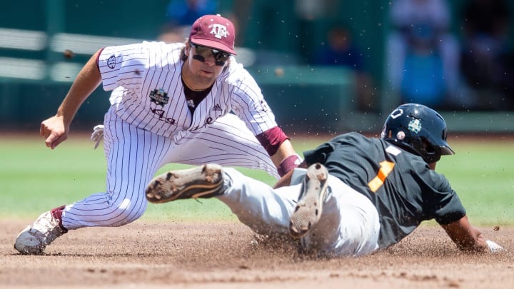 Tennessee's Christian Moore (1) safely dives into second base during game two of the NCAA College World Series finals between Tennessee and Texas A&M at Charles Schwab Field in Omaha, Neb., on Sunday, June 23, 2024.