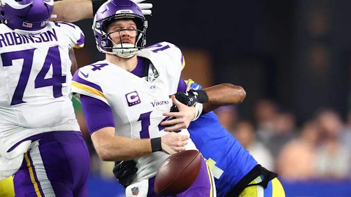 Jan 13, 2025; Glendale, AZ, USA; Minnesota Vikings quarterback Sam Darnold (14) is sacked by Los Angeles Rams cornerback Ahkello Witherspoon (4) causing a fumble during the first half in an NFC wild card game at State Farm Stadium.