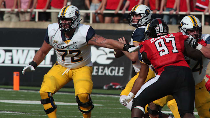 Oct 22, 2022; Lubbock, Texas, USA;  West Virginia Mountaineers offensive tackle Doug Nester (72) prepares to block for quarterback JT Daniels (18) as Texas Tech Red Raiders defensive tackle Tony Bradford Jr. (97) rushes in the second half at Jones AT&T Stadium and Cody Campbell Field. Mandatory Credit: Michael C. Johnson-Imagn Images