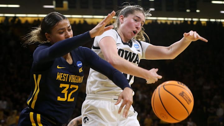 Iowa’s Kate Martin (20) and West Virginia’s Kyah Watson (32) reach for a loose ball in a NCAA Tournament round of 32 game Monday, March 25, 2024 at Carver-Hawkeye Arena.