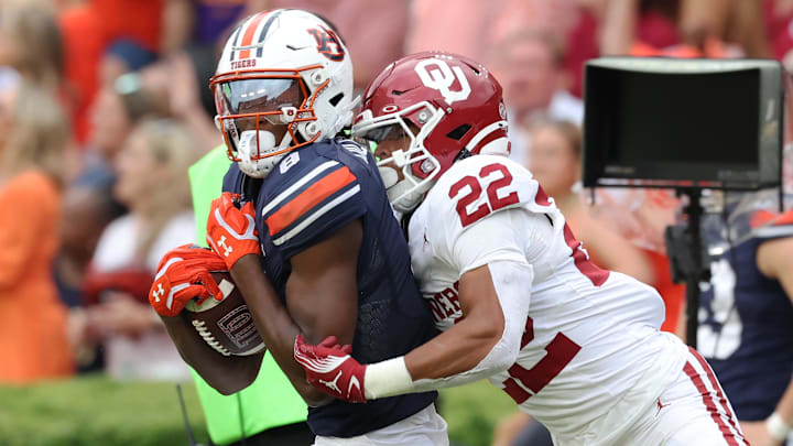 Auburn receiver Cam Coleman is tackled by Oklahoma safety Peyton Bowen.