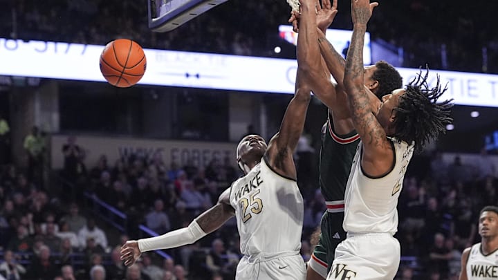 Jan 7, 2026; Winston-Salem, North Carolina, USA; Miami (FL) Hurricanes forward Malik Reneau (5) is surrounded by Wake Forest Demon Deacons forward Tre'von Spillers (25)  and forward Juke Harris (2) during the second half at Lawrence Joel Veterans Memorial Coliseum. Mandatory Credit: Jim Dedmon-Imagn Images
