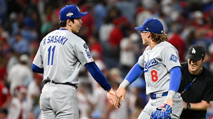 Oct 6, 2025; Philadelphia, Pennsylvania, USA; Los Angeles Dodgers pitcher Roki Sasaki (11) and left fielder Enrique Hernandez (8) celebrate after defeating the Philadelphia Phillies in game two of the NLDS round for the 2025 MLB playoffs at Citizens Bank Park. Mandatory Credit: Eric Hartline-Imagn Images