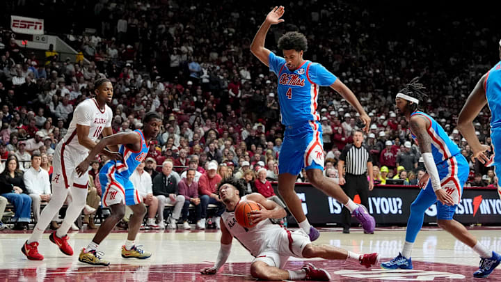 Jan 14, 2025; Tuscaloosa, AL, USA; Alabama guard Mark Sears (1) slips to the floor as he tries to get into the lane and is defended by Ole Miss forward Jaemyn Brakefield (4) at Coleman Coliseum. Ole Miss defeated Alabama 74-64. Mandatory Credit: Gary Cosby Jr.-Tuscaloosa News