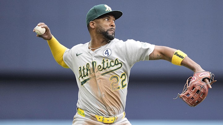 Athletics third baseman Miguel Andujar (22) throws to first base