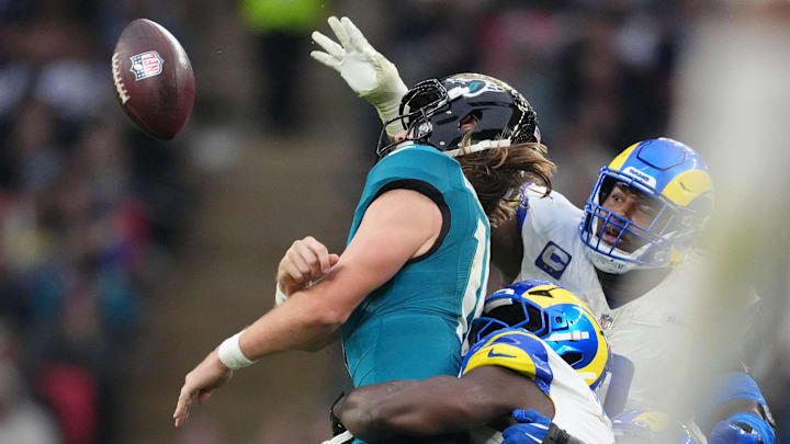 Oct 19, 2025; London, United Kingdom; Los Angeles Rams linebacker Bryon Young (0) tackles Jacksonville Jaguars quarterback Trevor Lawrence (16) during the second half of an NFL International Series game at Wembley Stadium. Mandatory Credit: Kirby Lee-Imagn Images