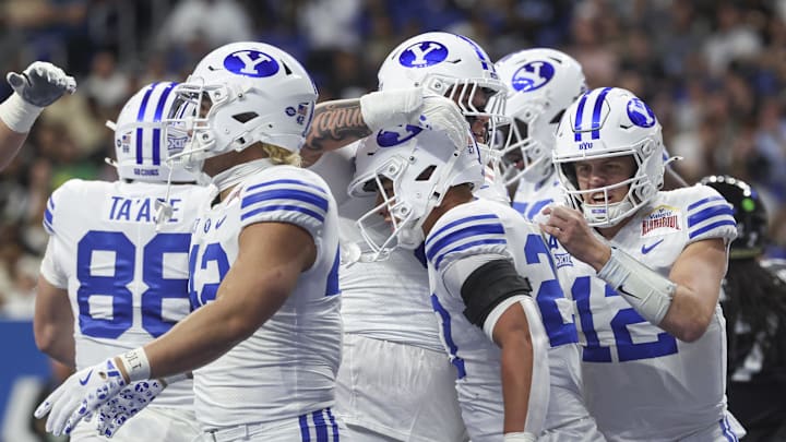 Dec 28, 2024; San Antonio, TX, USA; Brigham Young Cougars quarterback Jake Retzlaff (12) celebrates with running back LJ Martin (27) after Martin scores a touchdown during the first quarter against the Colorado Buffaloes at Alamodome. Mandatory Credit: Troy Taormina-Imagn Images