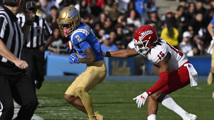 Nov 30, 2024; Pasadena, California, USA; UCLA Bruins wide receiver Titus Mokiao-Atimalala (2) catches a pass against Fresno State Bulldogs defensive back Julian Neal (15) during the second quarter at Rose Bowl. Mandatory Credit: Robert Hanashiro-Imagn Images