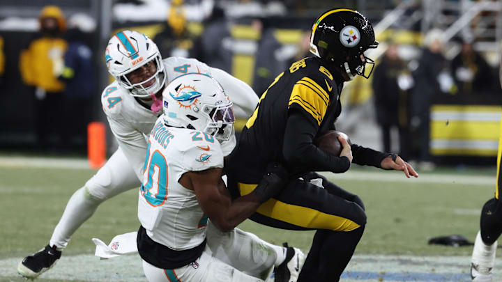 Pittsburgh Steelers quarterback Aaron Rodgers (8) is sacked by Miami Dolphins linebacker Jordyn Brooks (20) in the first quarter against the Miami Dolphins at Acrisure Stadium.