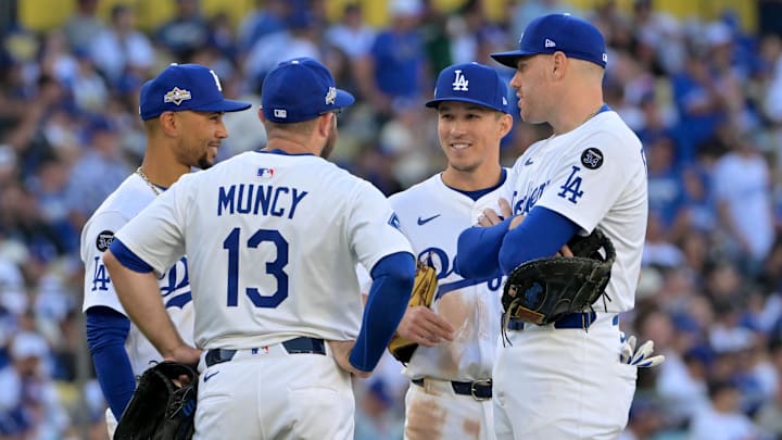 Oct 16, 2025; Los Angeles, California, USA; Los Angeles Dodgers third baseman Max Muncy (13) and shortstop Mookie Betts (50) and second baseman Tommy Edman (25) and first baseman Freddie Freeman (5) look on during a pitching change in the sixth inning against the Milwaukee Brewers during game three of the NLCS round for the 2025 MLB playoffs at Dodger Stadium. Mandatory Credit: Jayne Kamin-Oncea-Imagn Images