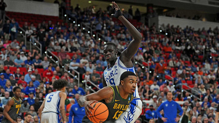 Mar 23, 2025; Raleigh, NC, USA; Baylor Bears guard Langston Love (13) drives to the basket during the first half as Duke Blue Devils center Khaman Maluach (9) defends in the second round of the NCAA Tournament at Lenovo Center. Mandatory Credit: Zachary Taft-Imagn Images