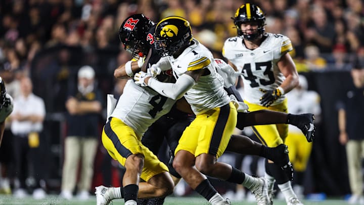 Sep 19, 2025; Piscataway, New Jersey, USA; Rutgers Scarlet Knights running back Antwan Raymond (3) is tackled by Iowa Hawkeyes defensive back Koen Entringer (4) and defensive back Xavier Nwankpa (1) during the first half at SHI Stadium. Mandatory Credit: Vincent Carchietta-Imagn Images