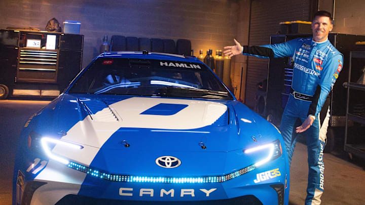 Denny Hamlin poses with his "living" No. 11 Progressive Toyota race car in Progressive's new "The Car Lives" promotional shoot.