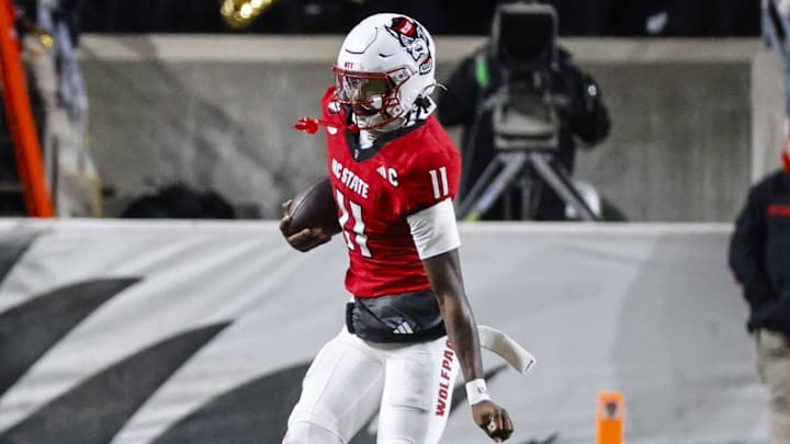 Nov 29, 2025; Raleigh, North Carolina, USA; NC State Wolfpack quarterback CJ Bailey (11) runs with the ball during the first half of the game against North Carolina Tar Heels at Carter-Finley Stadium. Mandatory Credit: Jaylynn Nash-Imagn Images Nov 29, 2025; Raleigh, North Carolina, USA; NC State Wolfpack quarterback CJ Bailey (11) runs with the ball during the first half of the game against North Carolina Tar Heels at Carter-Finley Stadium. Mandatory Credit: Jaylynn Nash-Imagn Images