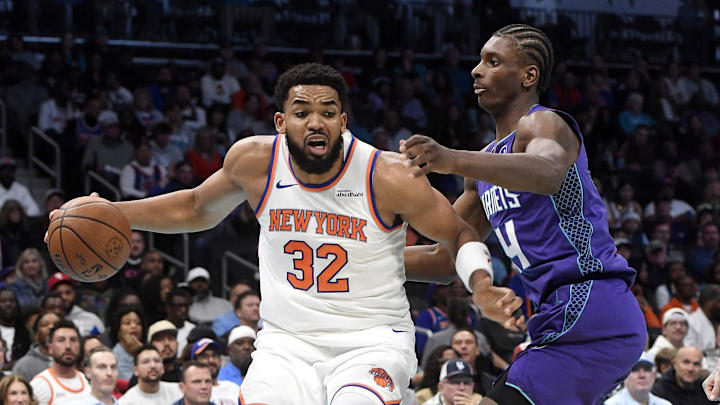 Nov 26, 2025; Charlotte, North Carolina, USA; New York Knicks center Karl-Anthony Towns (32) drives to the basket  past Charlotte Hornets forward Moussa Diabate (14) during the first half at the Spectrum Center. Mandatory Credit: Sam Sharpe-Imagn Images