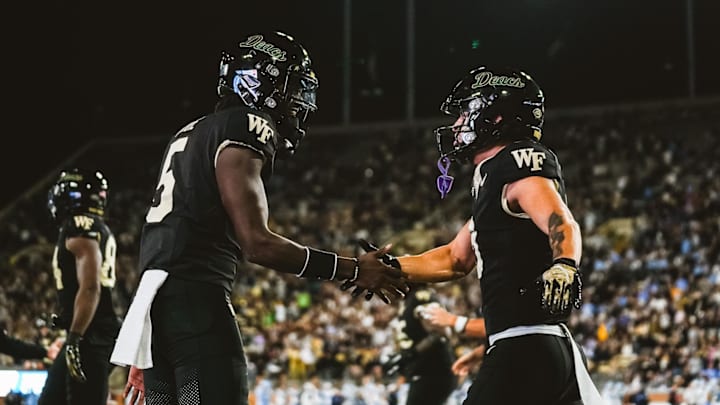 Nov 15, 2025; Winston-Salem, North Carolina, USA; Wake Forest Demon Deacons quarterback Deshawn Purdie (5) and wide receiver Carlos Hernandez (8) celebrate after a play against the North Carolina Tar Heels at Allegacy Federal Credit Union Stadium. Mandatory Credit: Wake Forest Athletics via Imagn Images