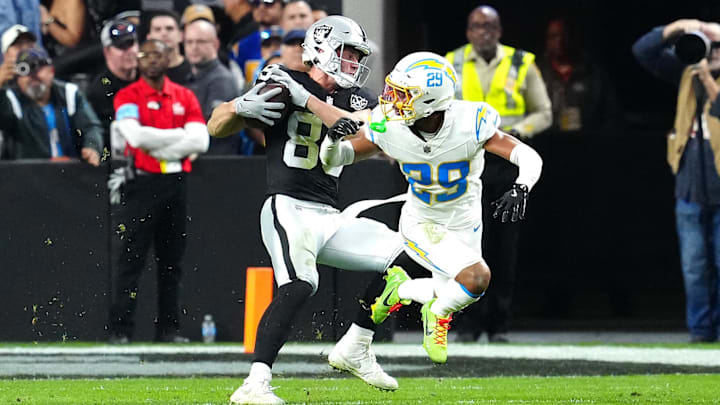 Jan 5, 2025; Paradise, Nevada, USA; Las Vegas Raiders tight end Brock Bowers (89) slips the tackle of Los Angeles Chargers cornerback Tarheeb Still (29) during the fourth quarter at Allegiant Stadium. Mandatory Credit: Stephen R. Sylvanie-Imagn Images