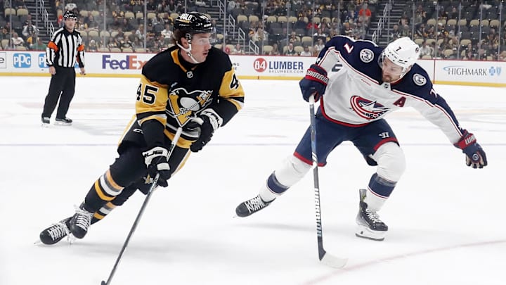 Oct 4, 2024; Pittsburgh, Pennsylvania, USA;  Pittsburgh Penguins defenseman Harrison Brunicke (45) skates in on goal against Columbus Blue Jackets center Sean Kuraly (7) during the first period at PPG Paints Arena. Mandatory Credit: Charles LeClaire-Imagn Images