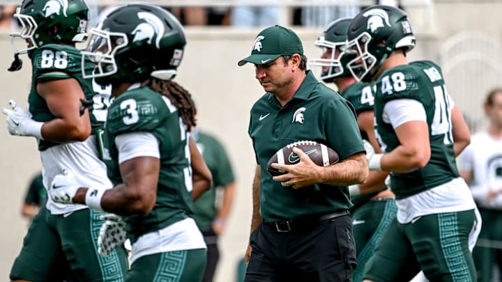 Michigan State's head coach Jonathan Smith holds a football as the team warms up before the game against Youngstown State on Saturday, Sept. 13, 2025, at Spartan Stadium in East Lansing.