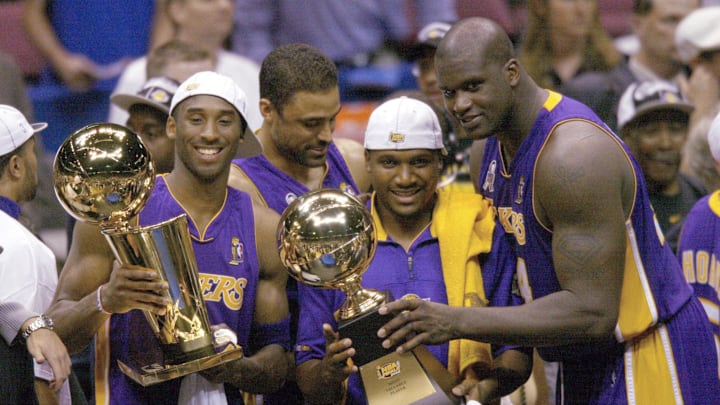 June 12, 2002; East Rutherford, NJ, USA;  (left to right) Los Angeles Lakers Kobe Bryant,  Lindsay Hunter and Shaquille O'Neal hold championship trophies after winning Game 4 of the NBA Finals at The Meadowlands. Mandatory Credit: Robert Deutsch-Imagn Images