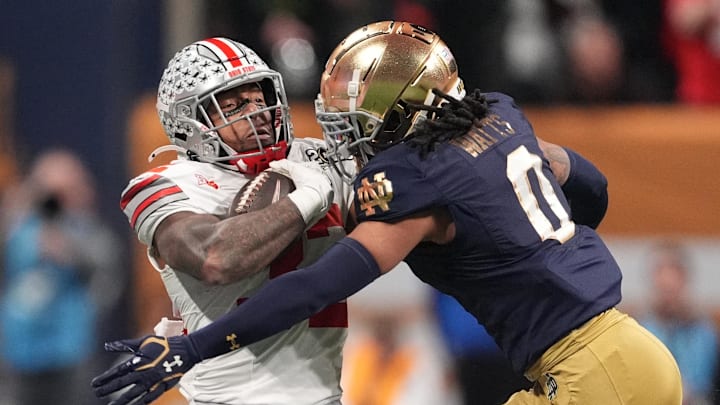 Jan 20, 2025; Atlanta, GA, USA; Ohio State Buckeyes running back TreVeyon Henderson (32)is tackled by Notre Dame Fighting Irish safety Xavier Watts (0) in the first half in the CFP National Championship college football game at Mercedes-Benz Stadium. Mandatory Credit: Dale Zanine-Imagn Images Jan 20, 2025; Atlanta, GA, USA; Ohio State Buckeyes running back TreVeyon Henderson (32)is tackled by Notre Dame Fighting Irish safety Xavier Watts (0) in the first half in the CFP National Championship college football game at Mercedes-Benz Stadium. Mandatory Credit: Dale Zanine-Imagn Images