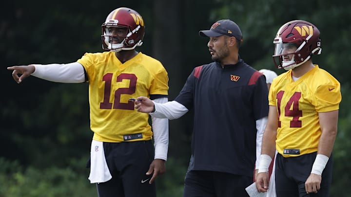 Jul 27, 2023; Ashburn, VA, USA; Washington Commanders quarterbacks coach Tavita Pritchard (M) talks with Washington Commanders quarterbacks Jacoby Brissett (12) and Sam Howell (14) during day two of Commanders training camp at OrthoVirginia Training Center. Mandatory Credit: Geoff Burke-Imagn Images